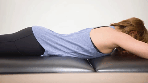 a woman deep breathing while laying on her stomach