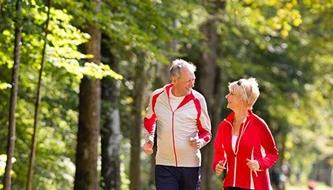 A senior couple jogs outdoors.